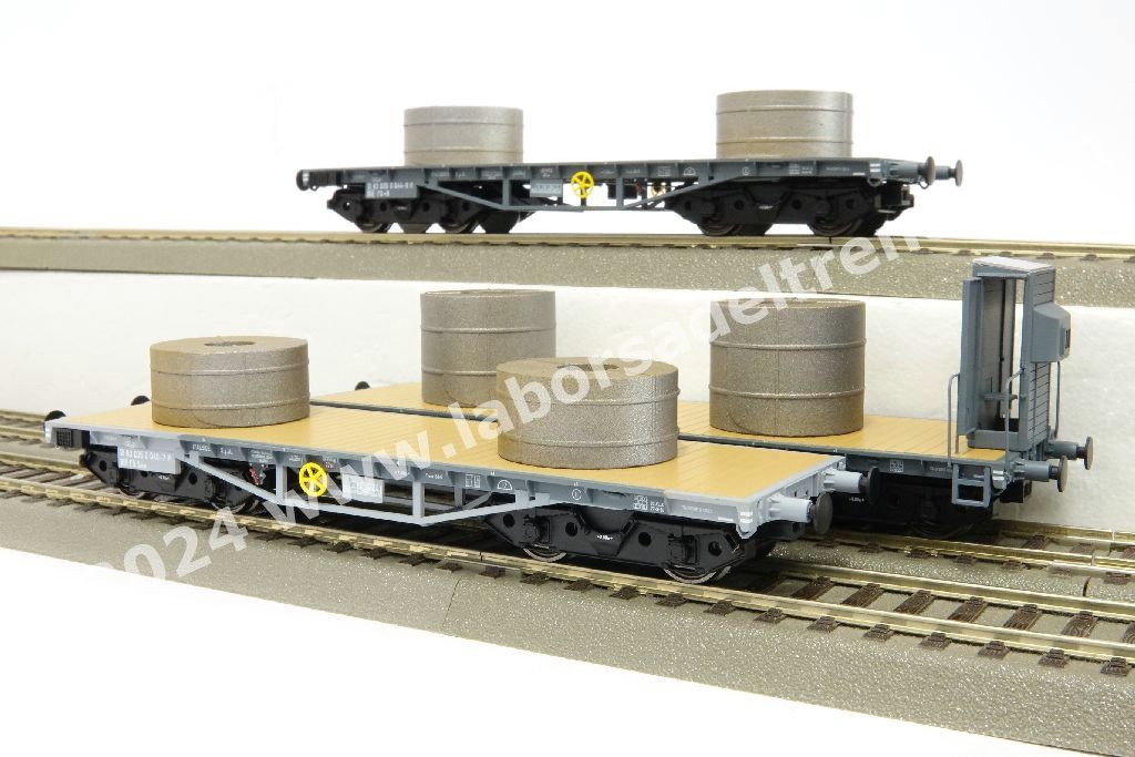 Set tre carri pianali a carrelli FS tipo R per trasporto rotoli di lamiere, uno con garitta, con carico di coils, livrea grigia, epoca IV